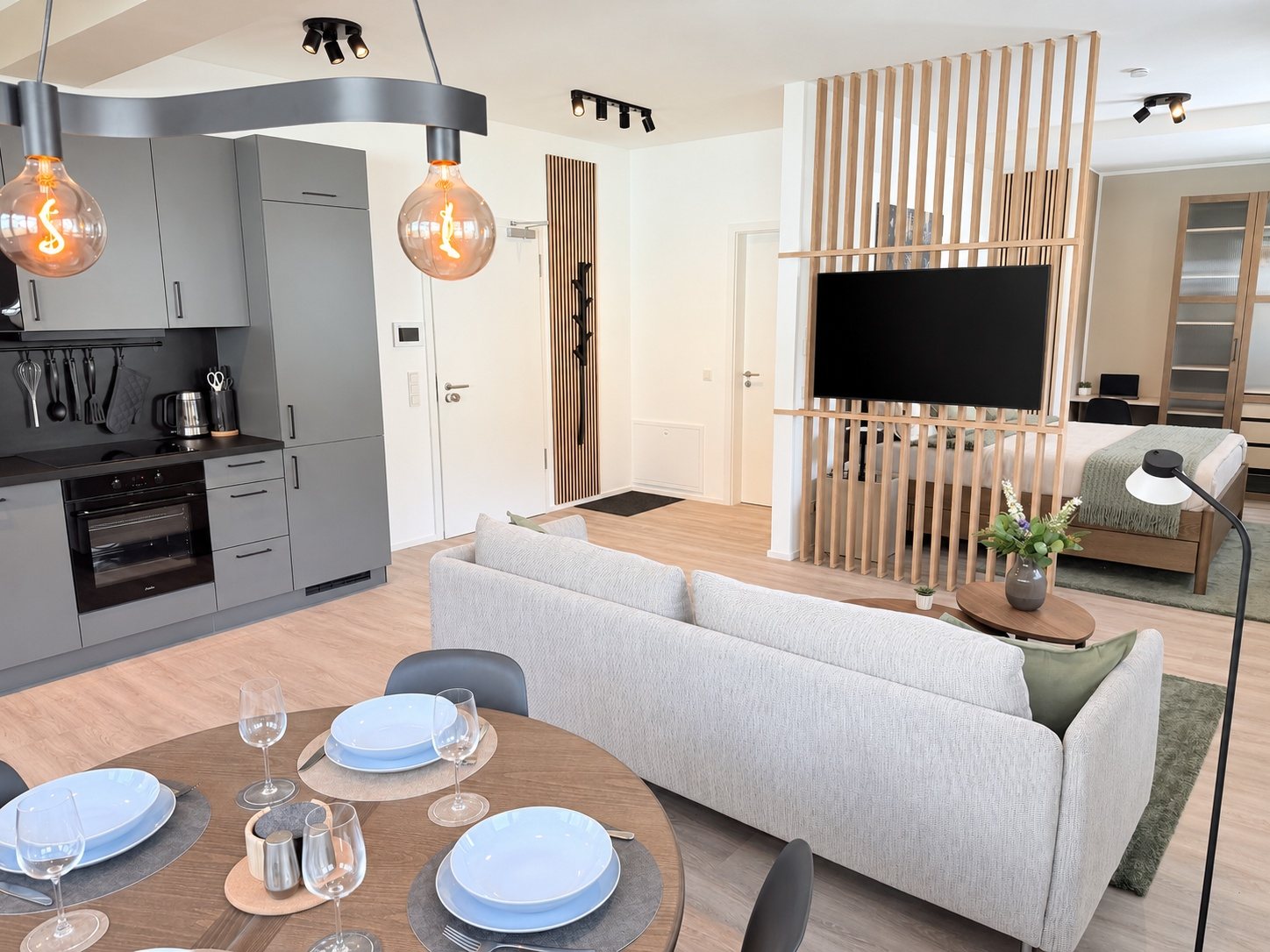 Apartment 1 Kordel – Blick vom Esstisch auf Küche und Wohnbereich mit Smart-TV