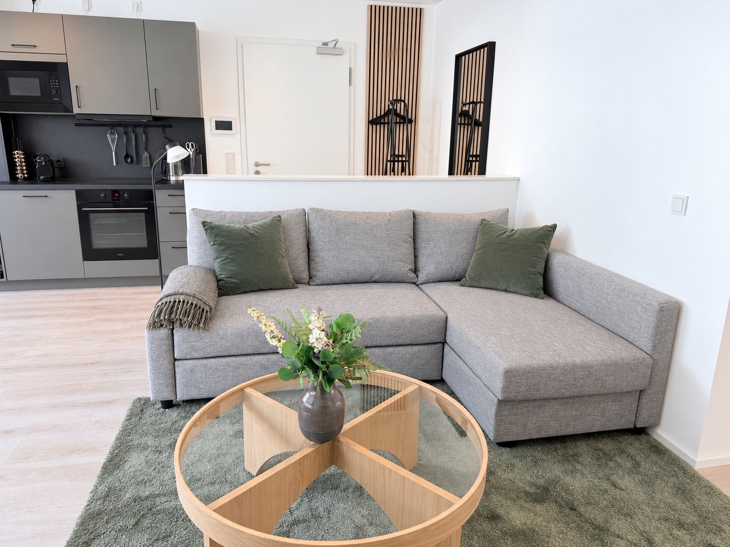 Apartment 2 Kordel – Ecksofa mit Couchtisch, Küche im Hintergrund
