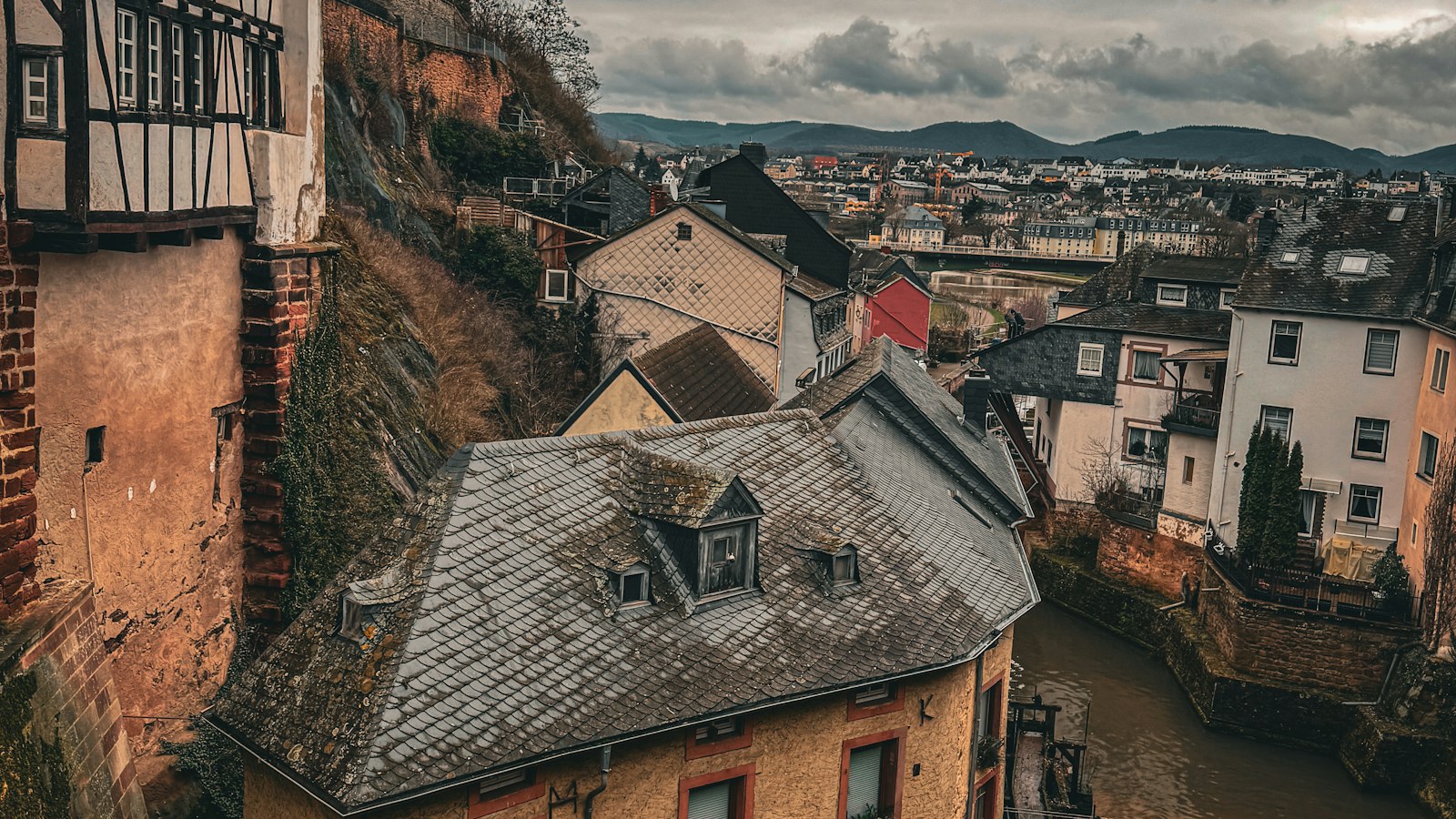 Oud Europees stadje aan een rivier onder een bewolkte hemel